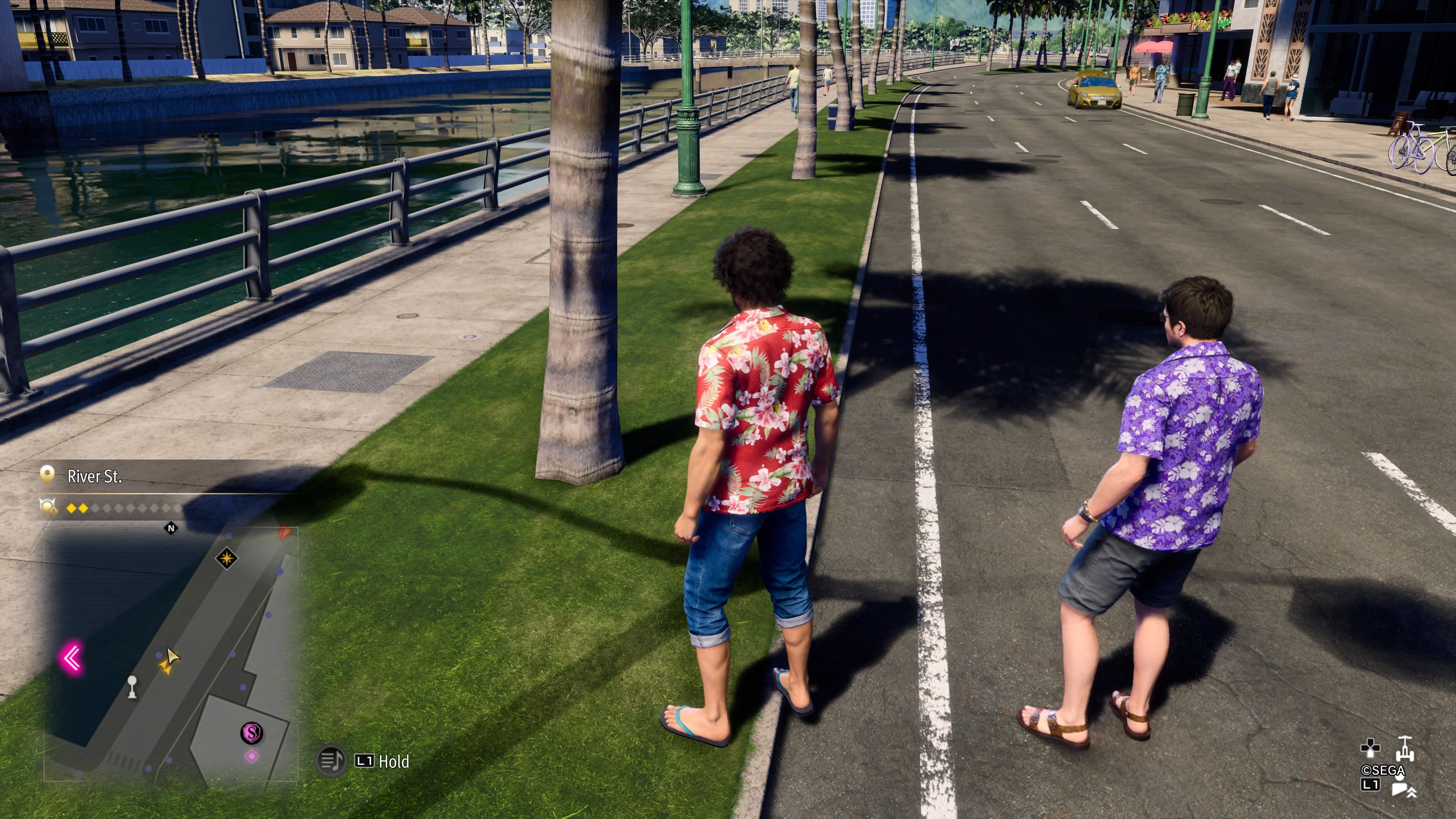 Kyosuke de pie junto a una palmera en River St., donde estaría un cofre del tesoro en Like A Dragon: Infinite Wealth.