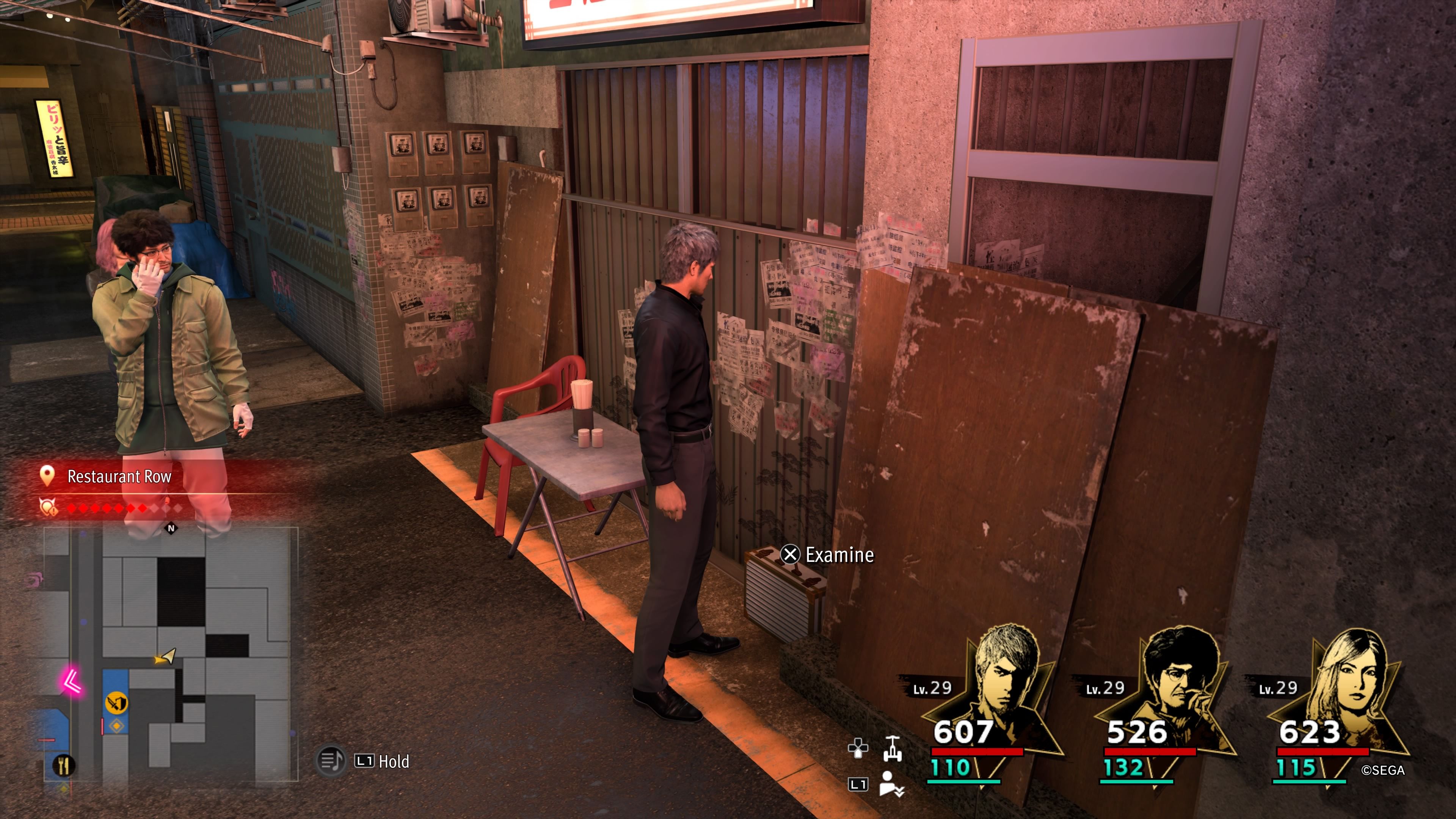 Kiryu de pie junto a una caja del tesoro en la parte trasera de un callejón en Restaurant Row en Like A Dragon: Infinite Wealth.