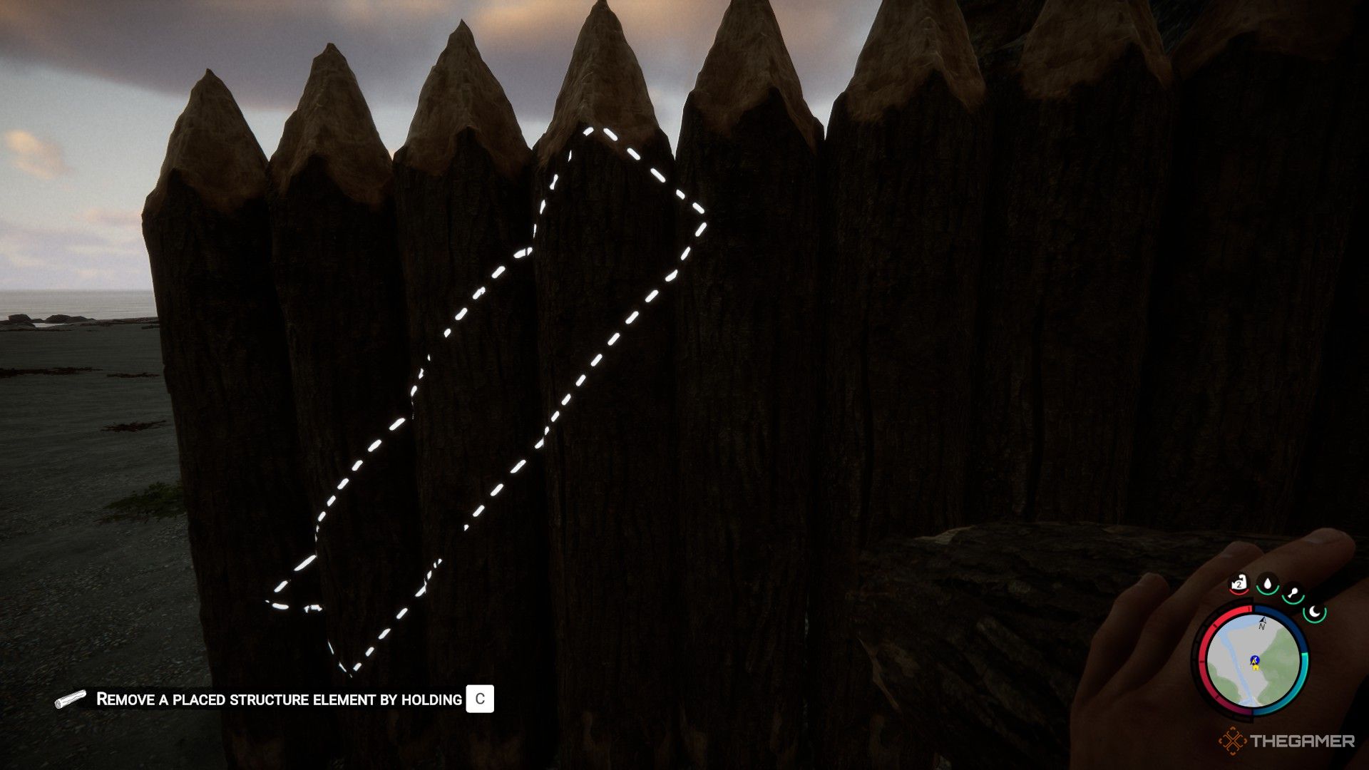 Una captura de pantalla de Sons of the Forest que muestra al personaje del jugador sosteniendo un tronco mientras mira un muro defensivo.  Un contorno blanco del tronco se muestra en diagonal en cinco troncos.