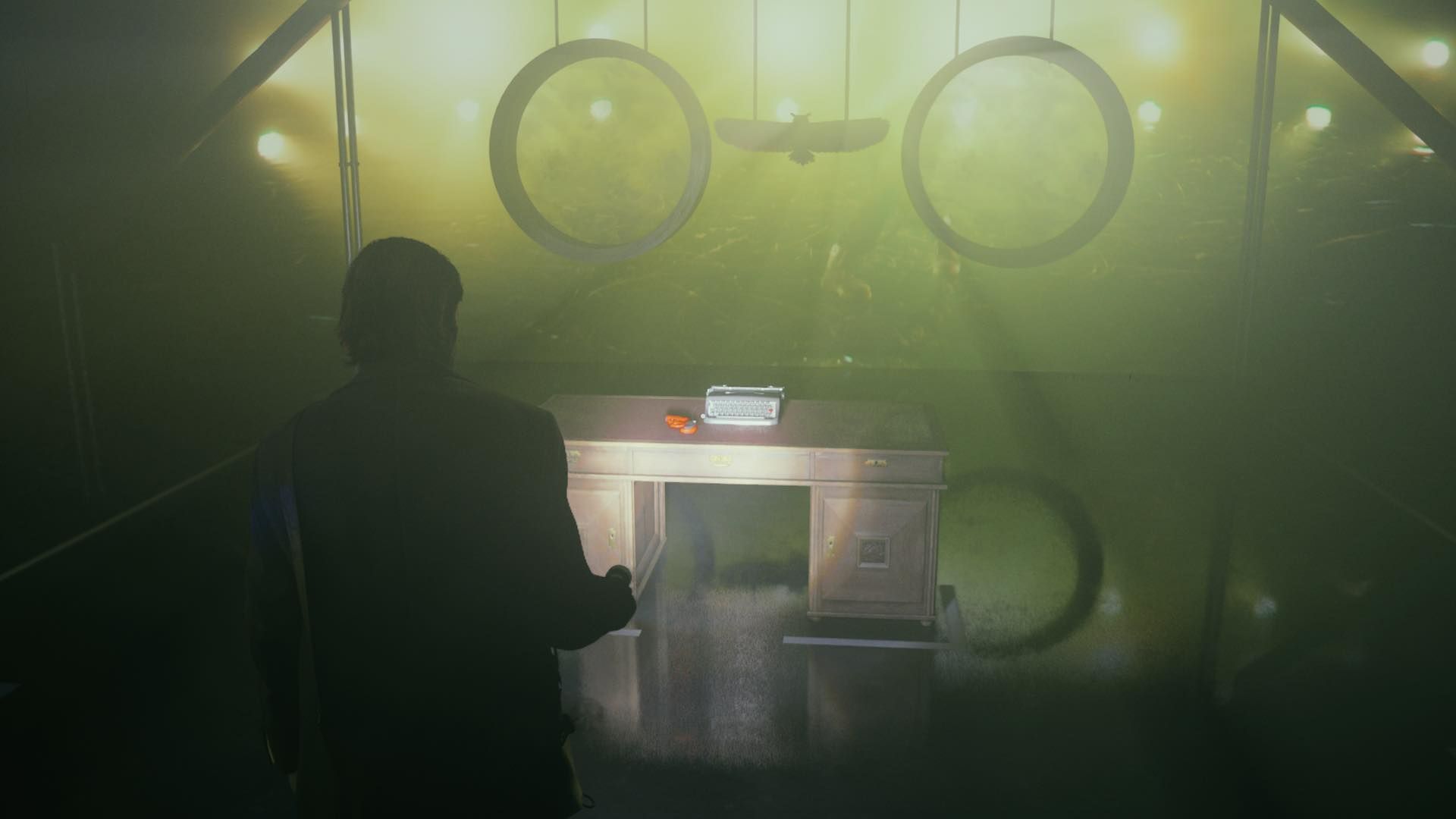 Alan apunta con su linterna a una pistola de bengalas que se encuentra encima de un escritorio dentro del estudio del programa de entrevistas en Alan Wake 2.