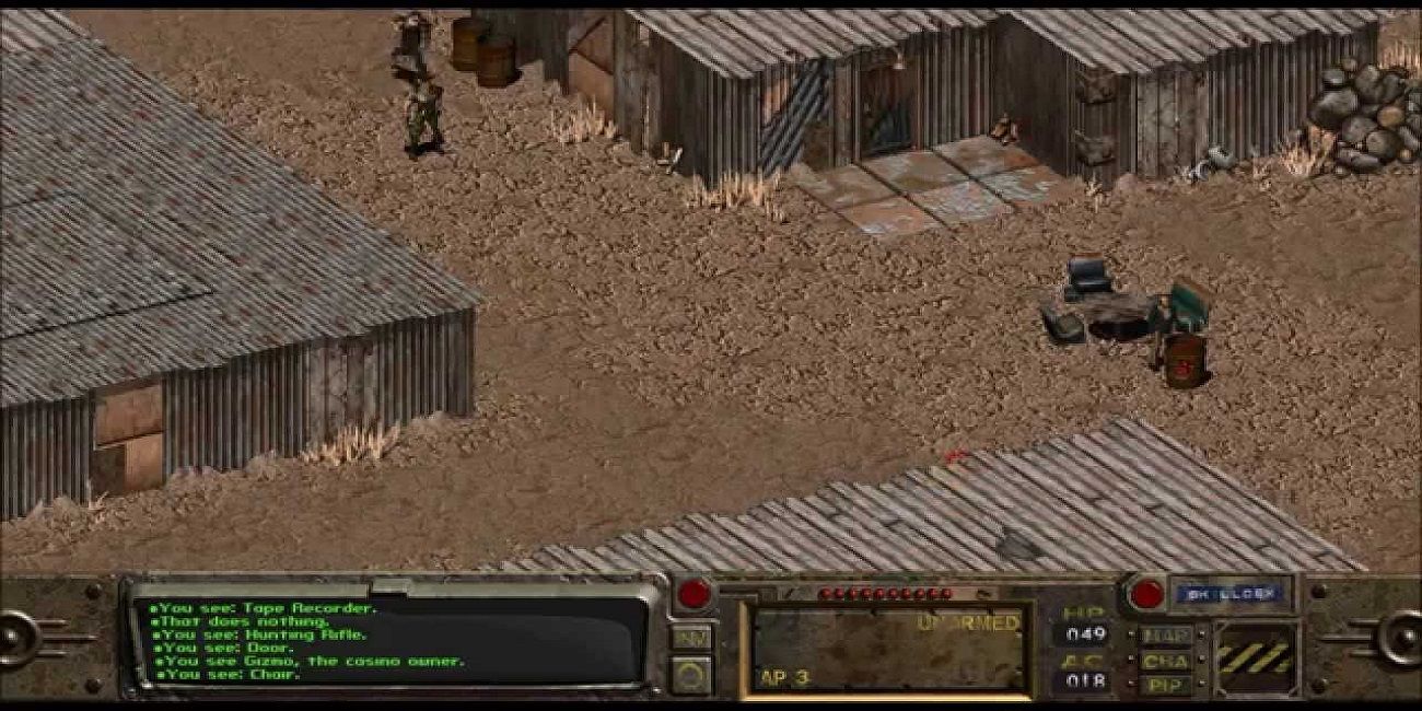 Una captura de pantalla del juego del Fallout original.  Un par de edificios en una zona desierta.