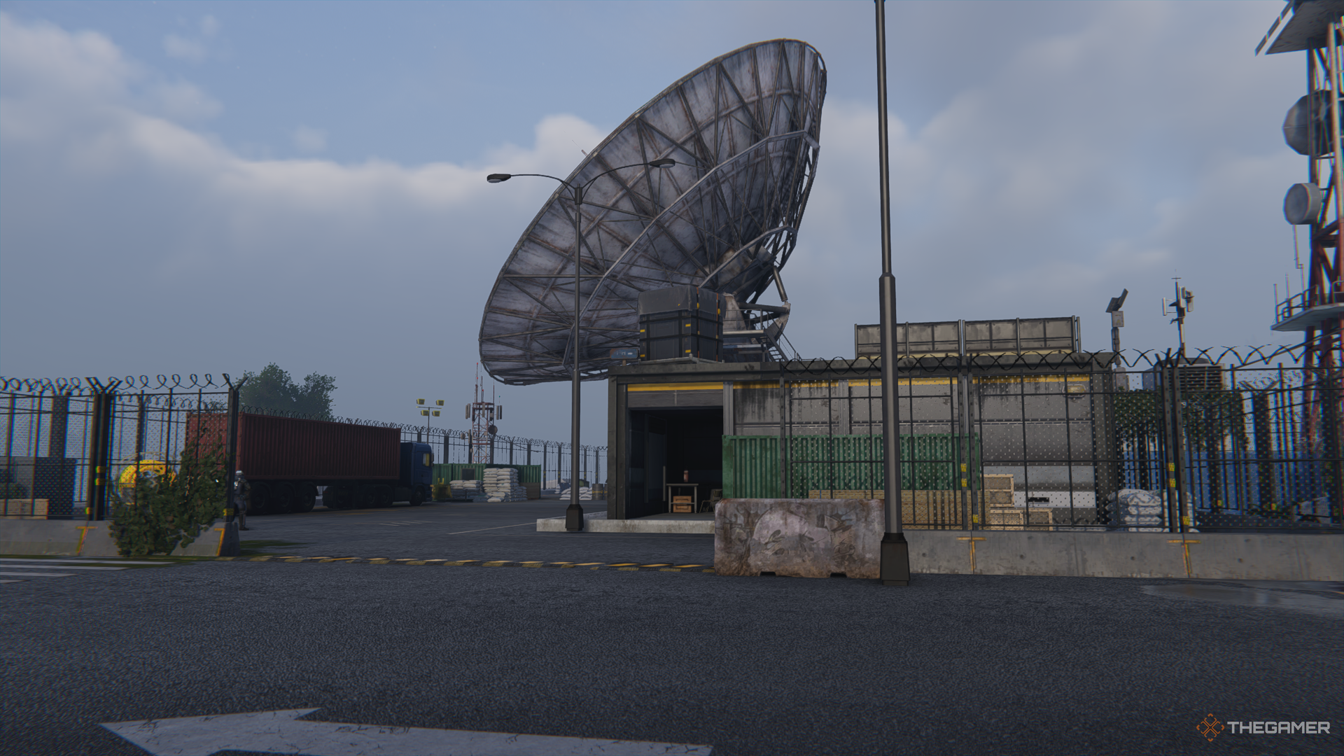 El edificio que contiene los registros del ejército en el puesto avanzado de Wild Dog Isle en Once Human, debajo de una antena parabólica gigante.