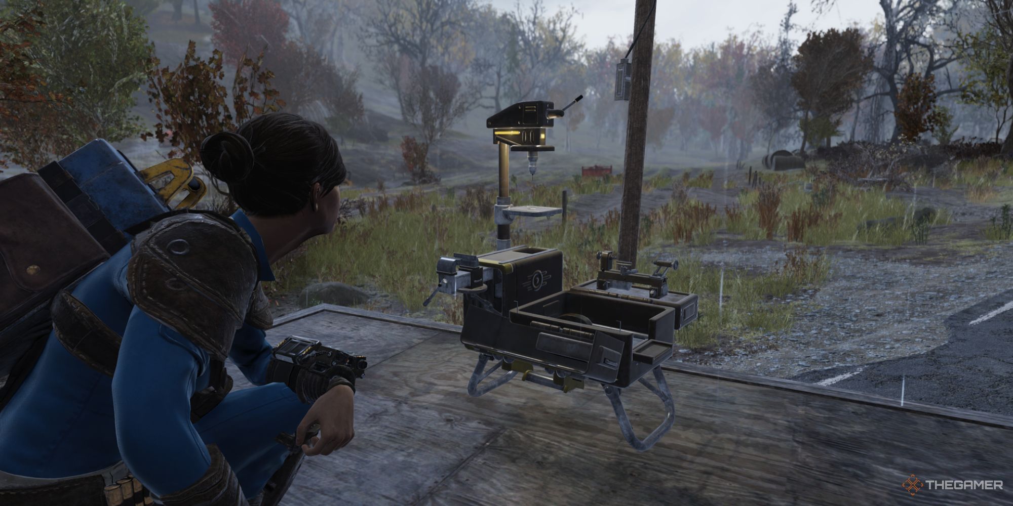 Un jugador agachado cerca de un dispositivo CAMP en las afueras de Wixon Homestead en Fallout 76.