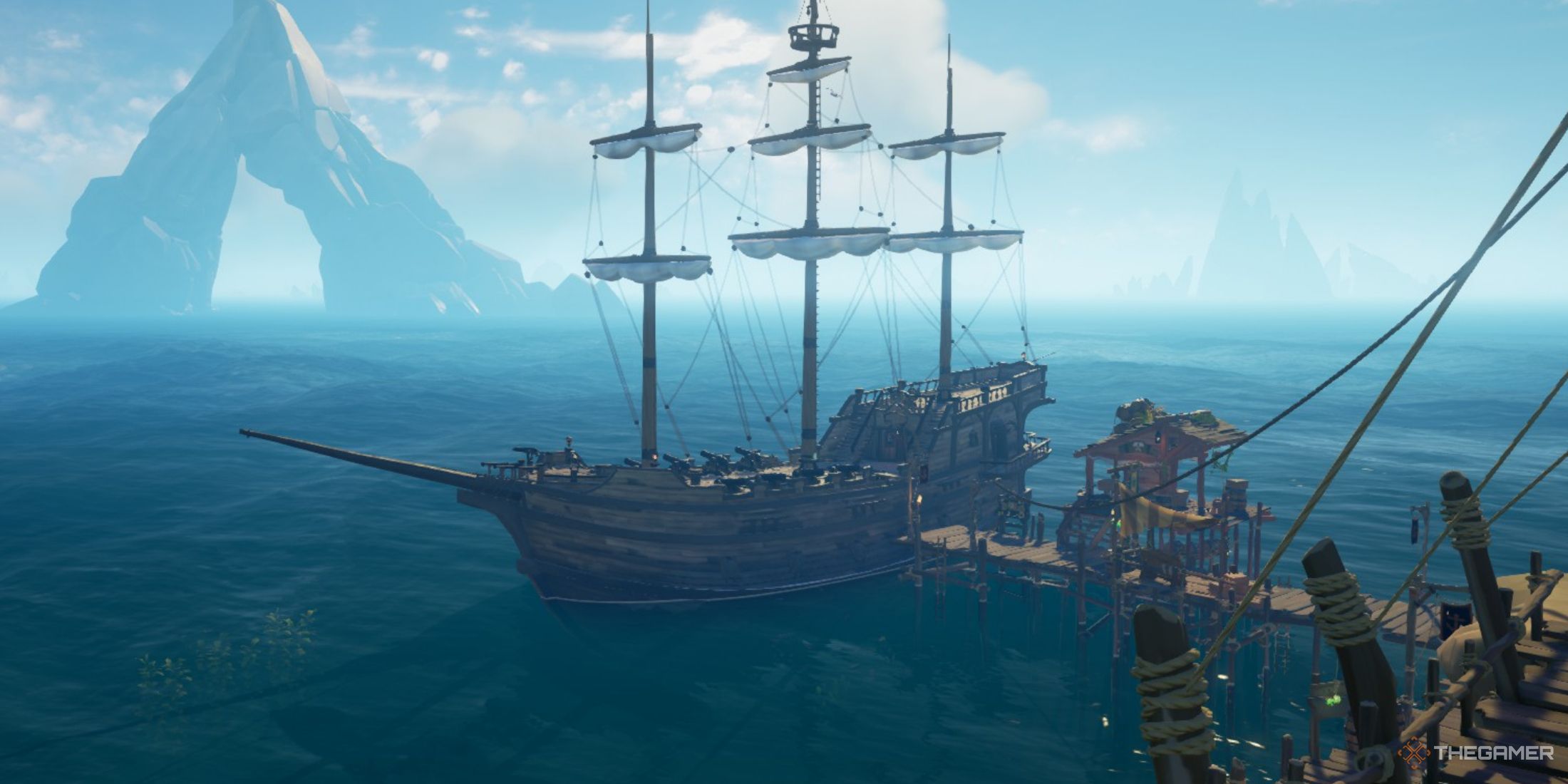 Una captura de pantalla de Sea of ​​Thieves que muestra el barco Galeón atracado con las velas izadas.