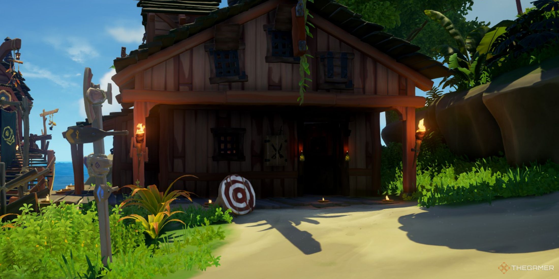 Una captura de pantalla de Sea of ​​Thieves que muestra el exterior de una tienda de armas con una diana roja y blanca y un gabinete de armería en la pared.