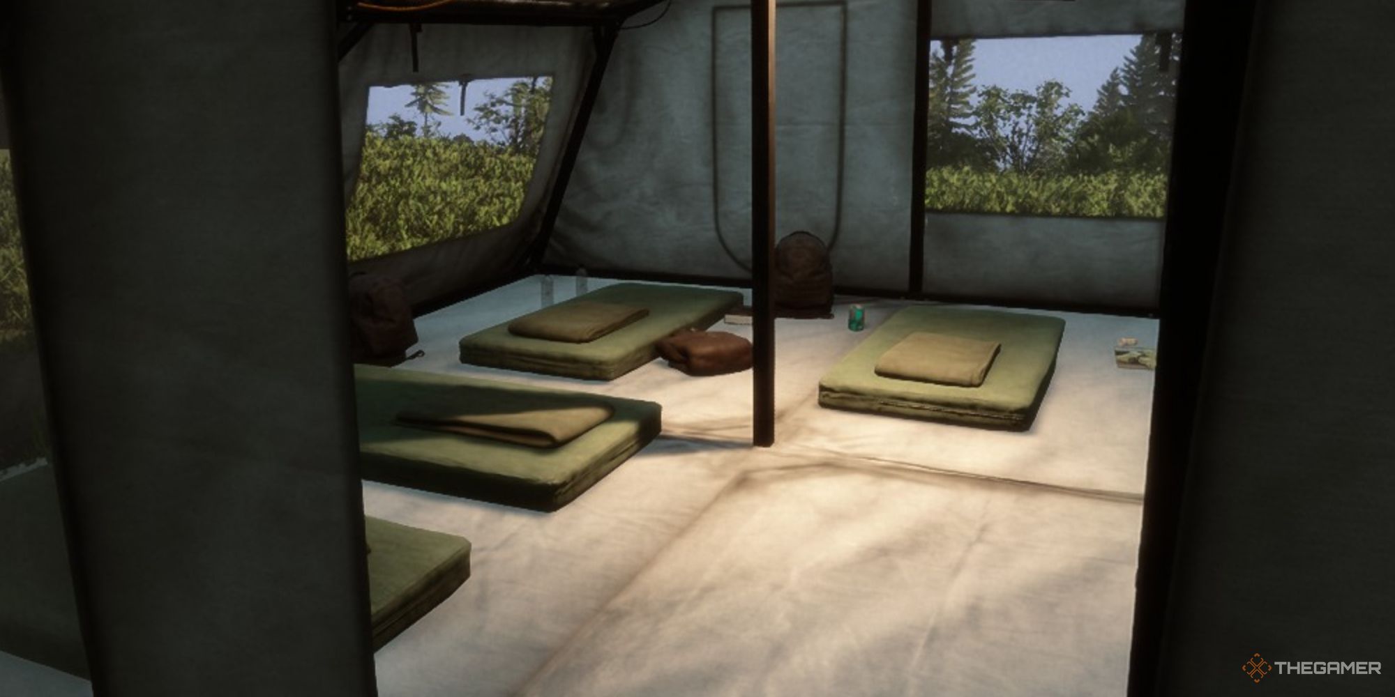 Una captura de pantalla de Sons of the Forest que muestra el interior de una gran tienda de campaña a través de una puerta, con una chaqueta roja hinchada cerca de un pequeño catre verde en la parte trasera de la tienda.